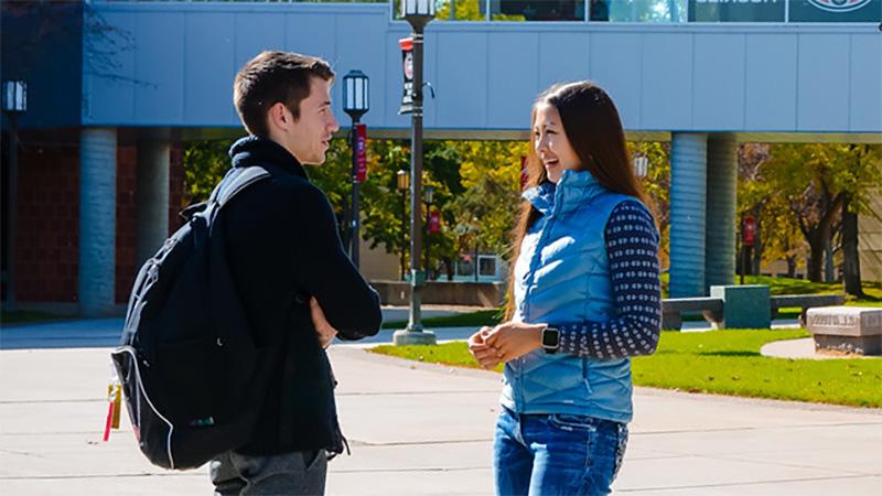 Two people talking on St. Cloud State campus
